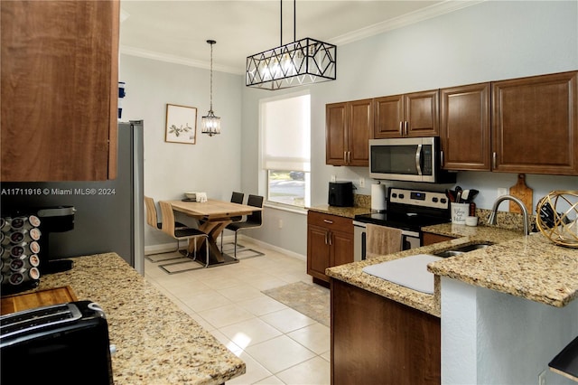 kitchen with pendant lighting, sink, ornamental molding, and stainless steel appliances