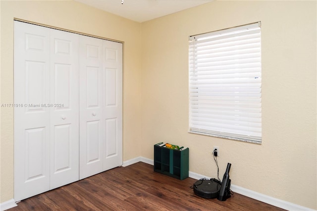 unfurnished bedroom featuring dark wood-type flooring and a closet