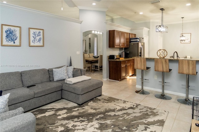 tiled living room featuring crown molding and sink