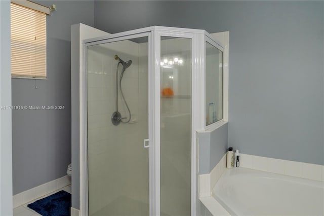 bathroom with tile patterned floors, toilet, and independent shower and bath