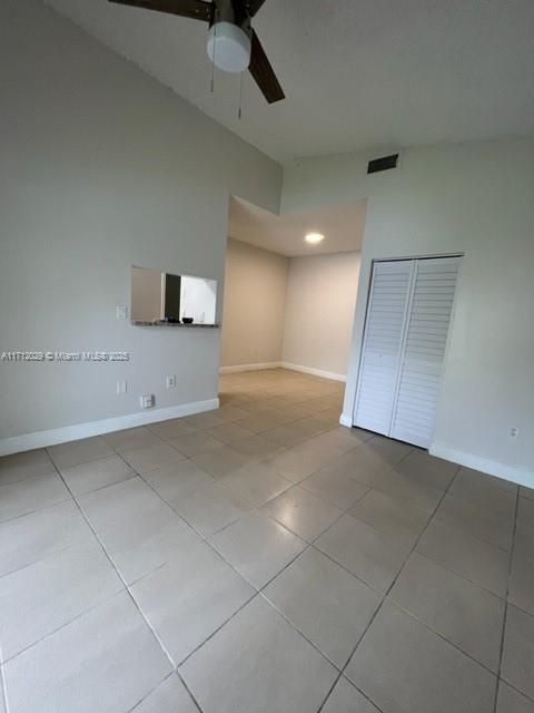 tiled empty room with ceiling fan