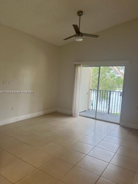 tiled spare room featuring ceiling fan