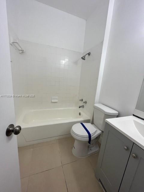 full bathroom featuring vanity, toilet, tile patterned floors, and tiled shower / bath