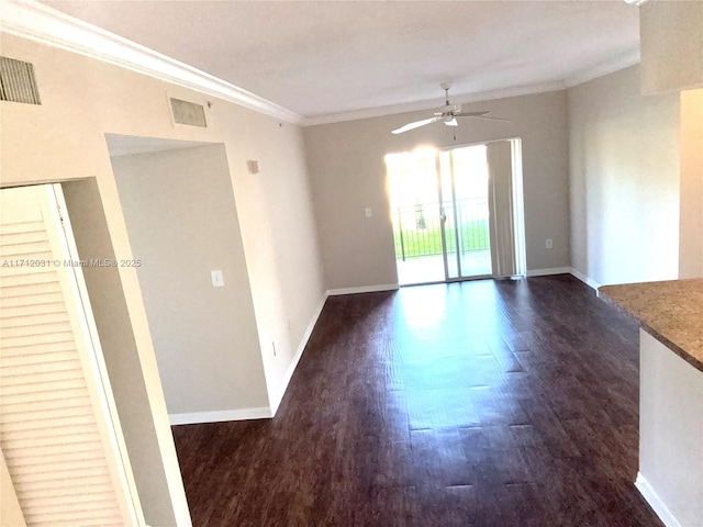 spare room with baseboards, ornamental molding, and dark wood-type flooring