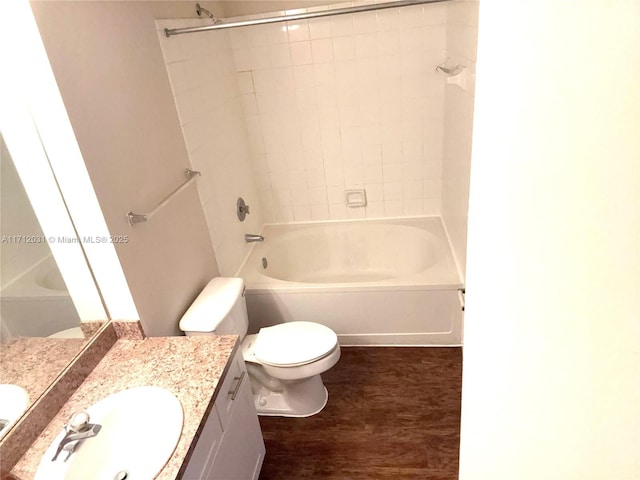 bathroom featuring  shower combination, vanity, toilet, and wood finished floors