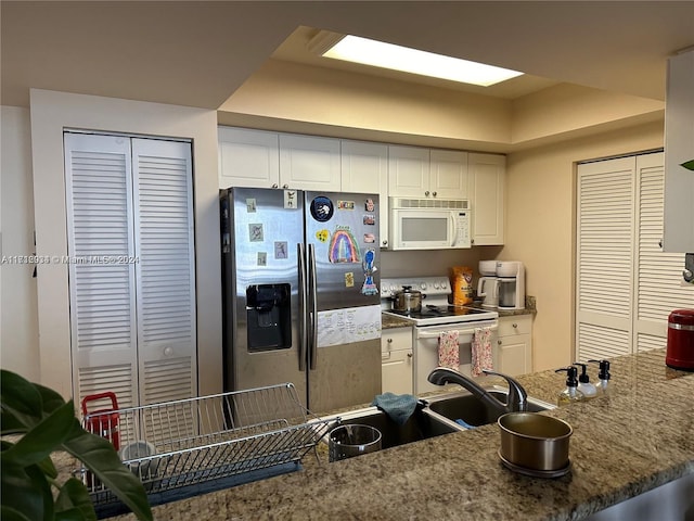 kitchen featuring white cabinets and white appliances