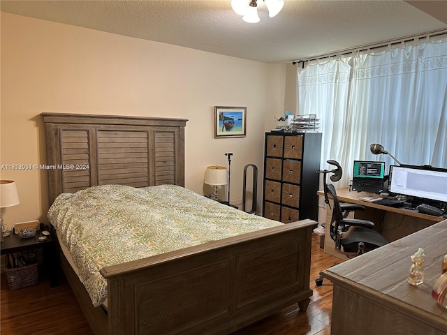 bedroom with wood-type flooring and a textured ceiling