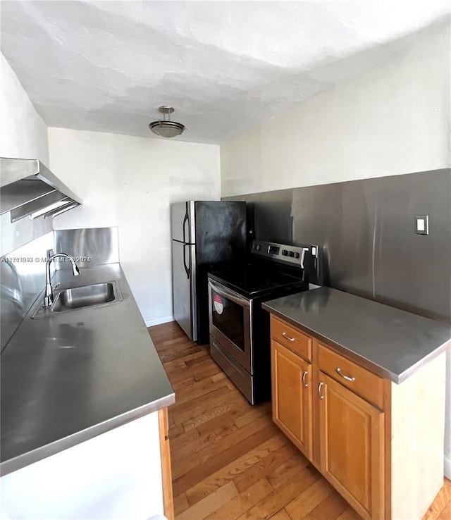 kitchen with light wood-type flooring, sink, and appliances with stainless steel finishes