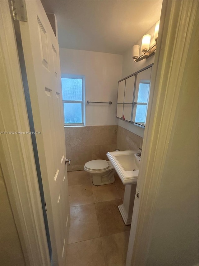 bathroom with tile patterned floors, plenty of natural light, tile walls, and toilet