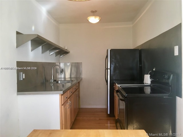 kitchen featuring sink, light hardwood / wood-style floors, and black range with electric cooktop