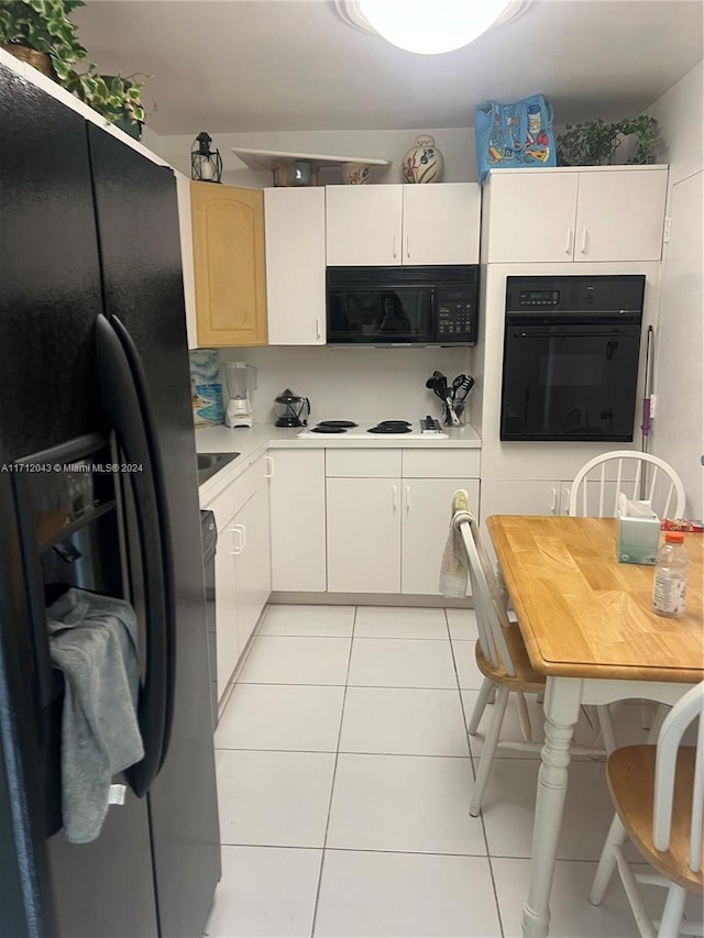 kitchen with black appliances and light tile patterned flooring