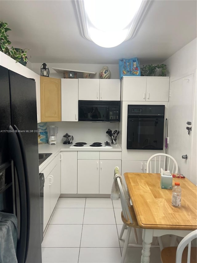 kitchen with black appliances, white cabinets, and light tile patterned floors