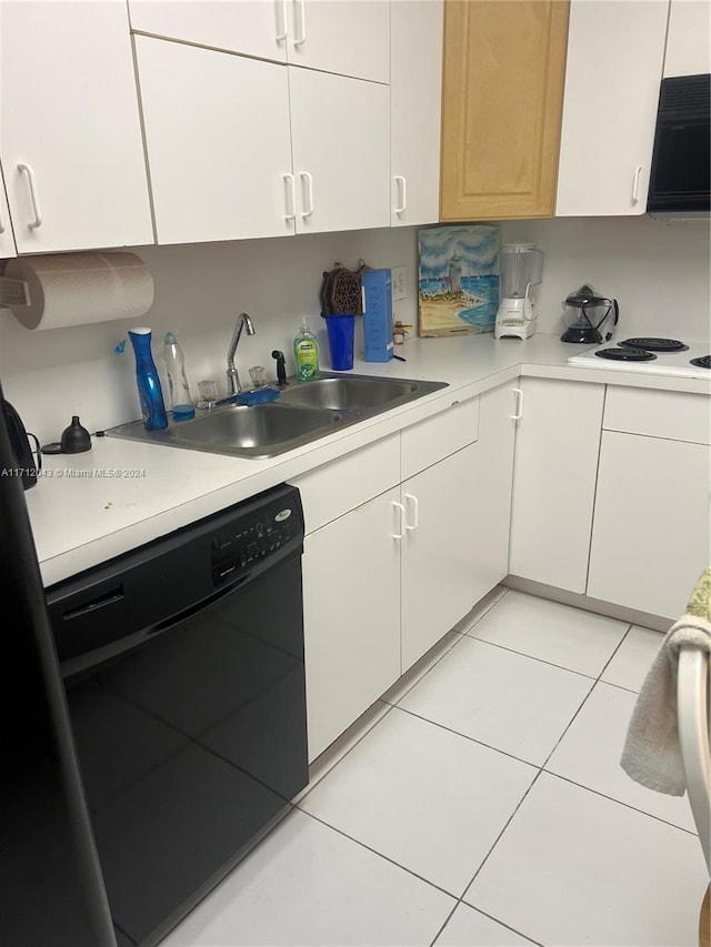 kitchen with light tile patterned flooring, sink, white cabinetry, and black appliances