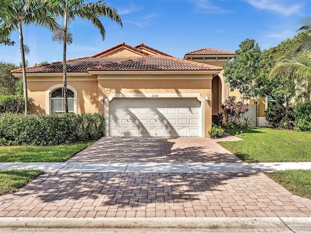 mediterranean / spanish-style house with a garage and a front lawn