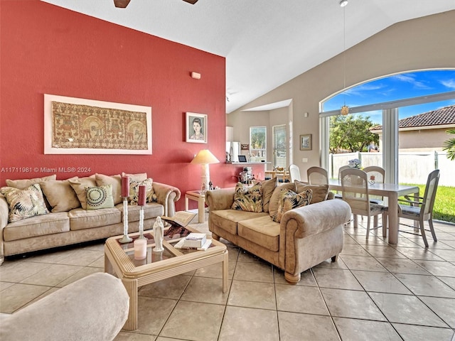 living room with ceiling fan, light tile patterned flooring, and lofted ceiling