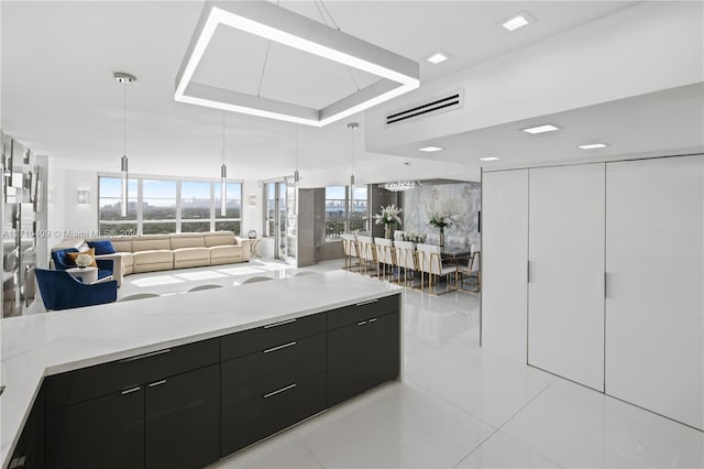 kitchen featuring decorative light fixtures, white cabinetry, light stone countertops, and light tile patterned floors