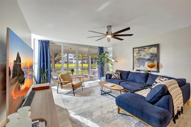 living room featuring ceiling fan and light hardwood / wood-style flooring