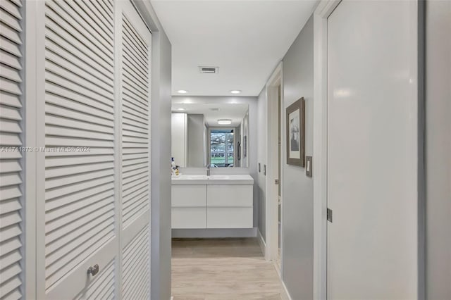 corridor with sink and light hardwood / wood-style floors