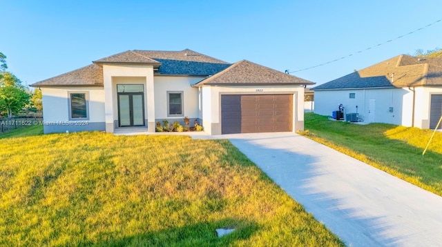 view of front of house with a garage, a front lawn, and central air condition unit