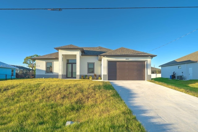 view of front of home with cooling unit, a front lawn, and a garage