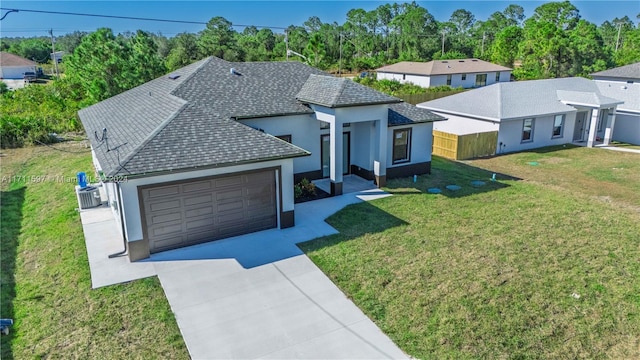 view of front of home with cooling unit, a garage, and a front lawn