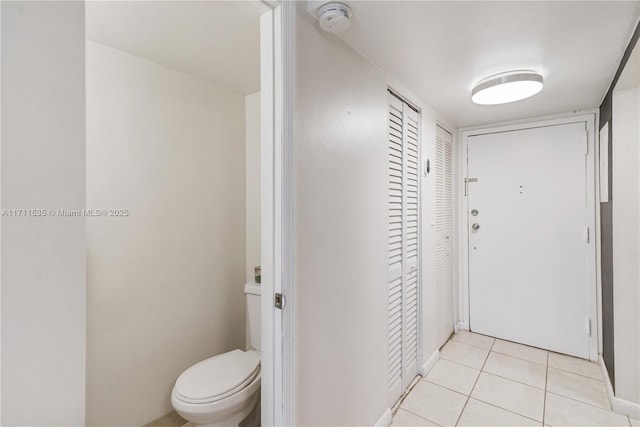 interior space with toilet and tile patterned floors