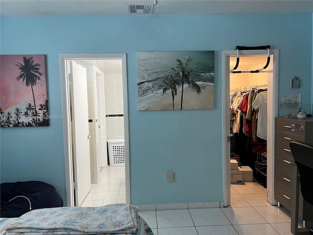 bedroom featuring a spacious closet, light tile patterned floors, and a closet