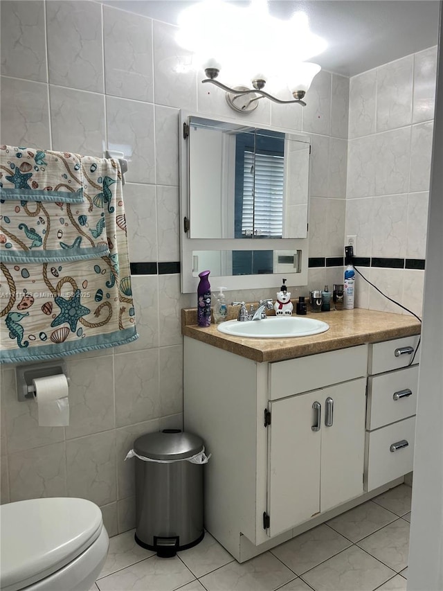 bathroom with toilet, tile patterned flooring, tile walls, and vanity