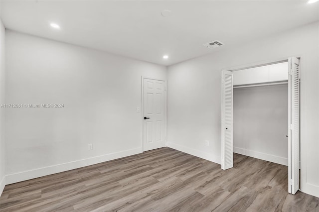 unfurnished bedroom with a closet and light hardwood / wood-style flooring