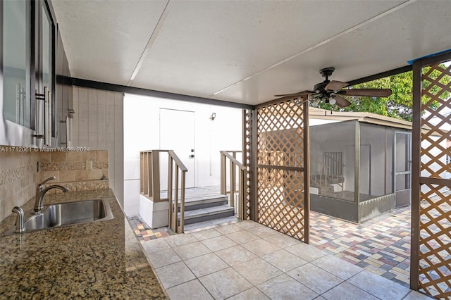 view of patio featuring a sunroom, ceiling fan, and sink