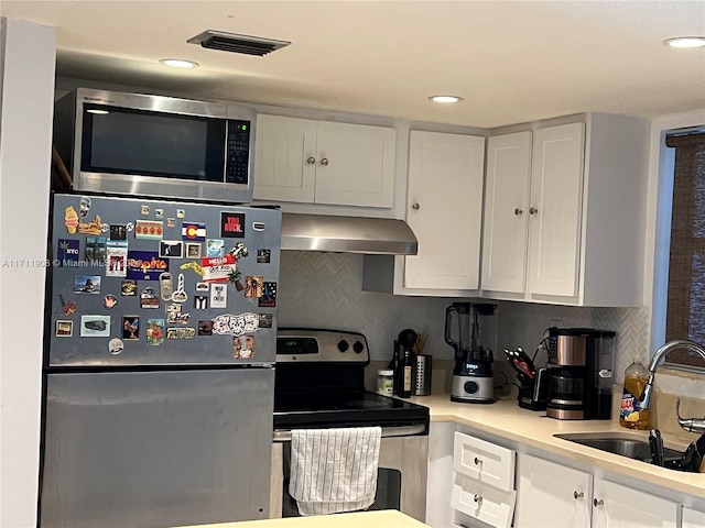 kitchen with backsplash, sink, range hood, white cabinetry, and stainless steel appliances