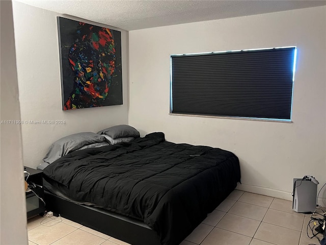 bedroom with a textured ceiling and light tile patterned flooring