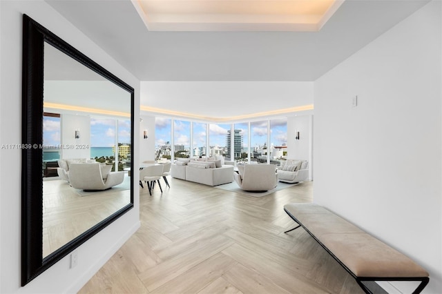 living room featuring a raised ceiling and light parquet floors