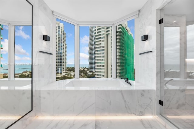 bathroom with plenty of natural light, a water view, and independent shower and bath