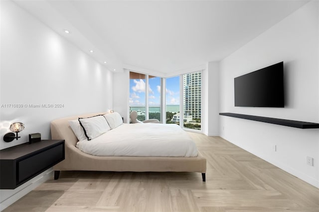 bedroom with floor to ceiling windows and light parquet flooring