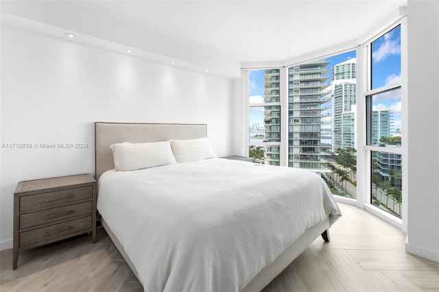 bedroom featuring light parquet floors, floor to ceiling windows, and multiple windows