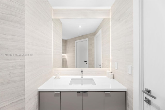 bathroom featuring vanity and tile walls