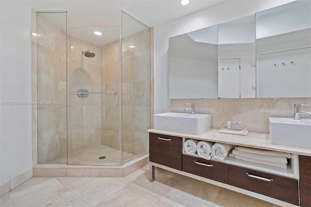 bathroom featuring decorative backsplash, vanity, and a shower with shower door