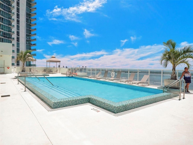 view of swimming pool with a water view and a patio