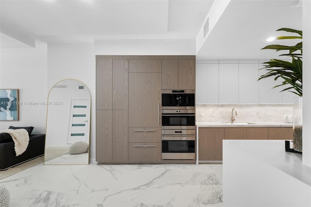 kitchen with backsplash, sink, and double oven