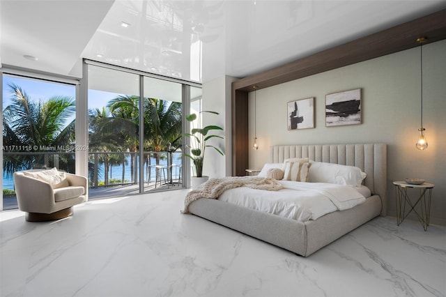 bedroom featuring access to outside, expansive windows, and a water view