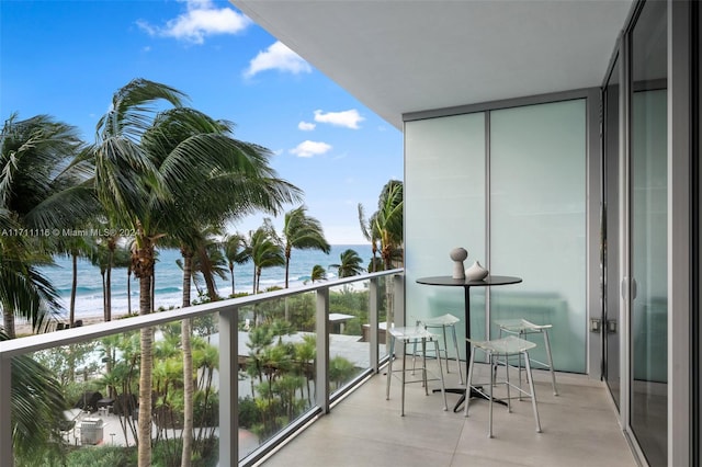 balcony with a water view and a beach view