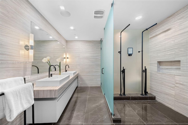 bathroom featuring vanity, a shower with door, and tile walls