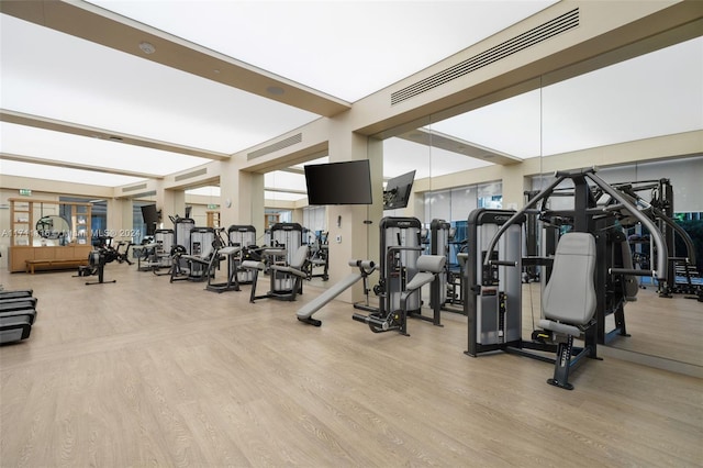 workout area with light hardwood / wood-style flooring