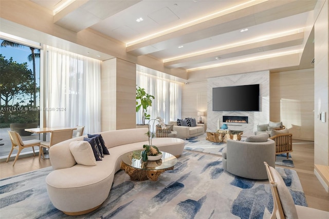 living room featuring a wealth of natural light, a high end fireplace, and hardwood / wood-style flooring