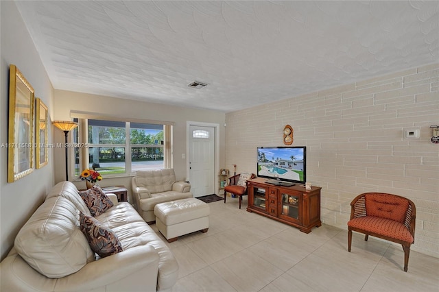 tiled living room featuring a textured ceiling