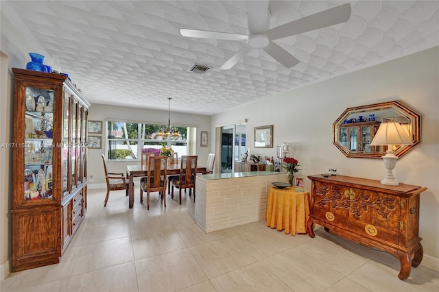 dining room featuring ceiling fan, light tile patterned floors, and a textured ceiling