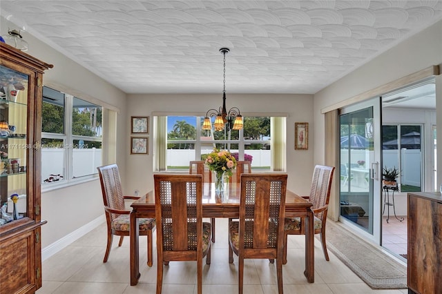 dining space featuring plenty of natural light, light tile patterned flooring, and a notable chandelier