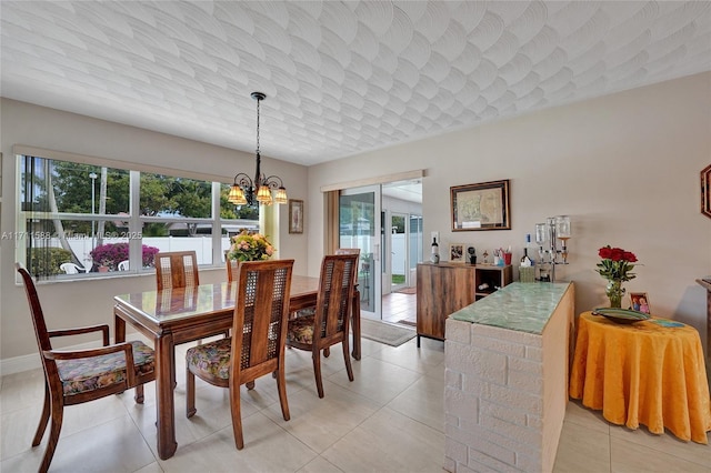 dining space with light tile patterned floors and an inviting chandelier