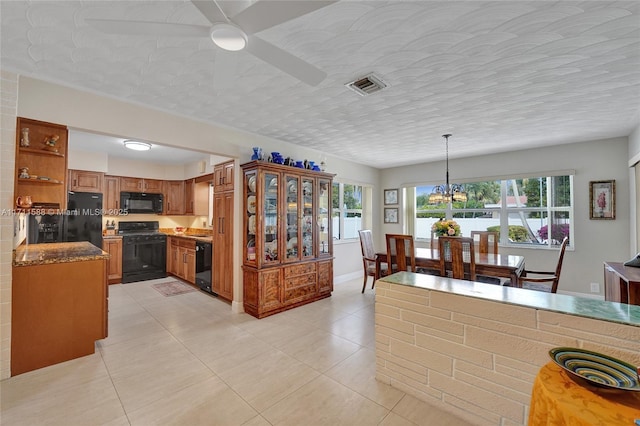 kitchen with a chandelier, a healthy amount of sunlight, pendant lighting, and black appliances